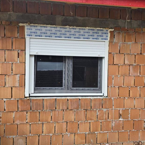 Bela roletna sa kutijom iznad prozora